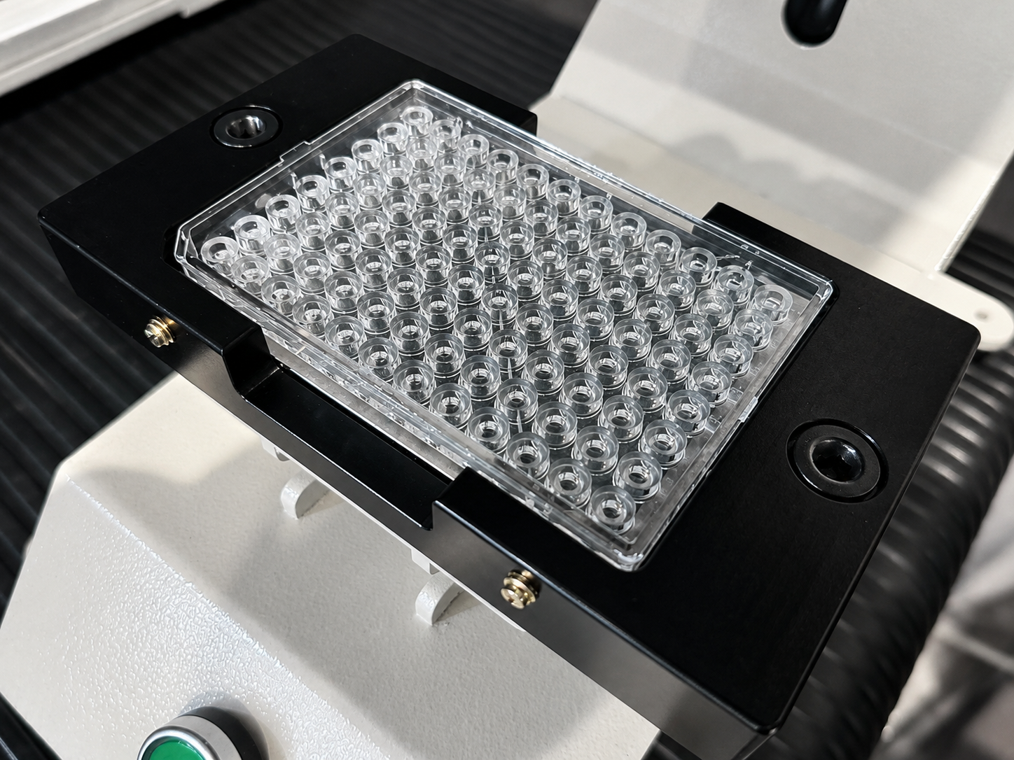 Image of multi-well consumable positioned in a precision fixture during imaging-based instrument development.